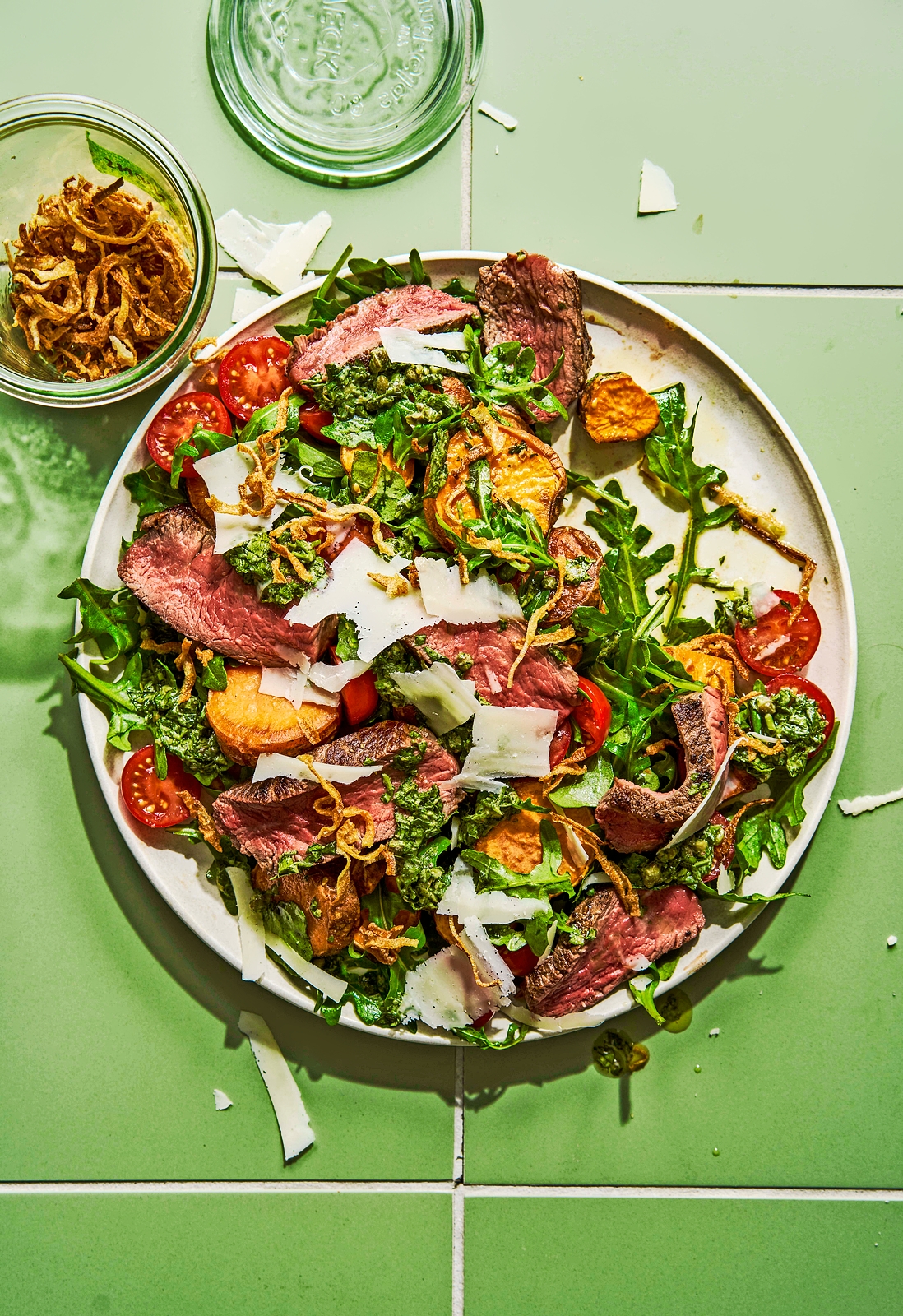 Steak salad with sweet potatoes, arugula, tomatoes, parmesan, and a sesame miso dressing.